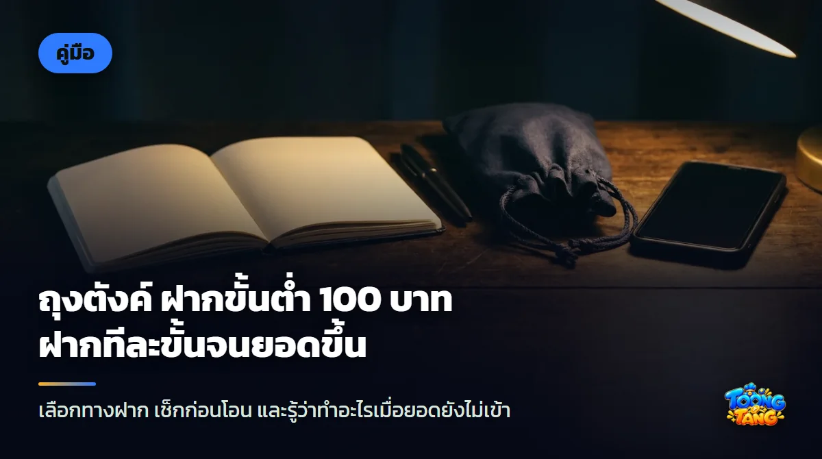 ถุงผ้าสีน้ำเงินผูกเชือกวางข้างสมาร์ตโฟนจอดับ สมุดโน้ตเปิดอยู่ และปากกา บนโต๊ะไม้สีเข้มใต้แสงไฟอุ่น