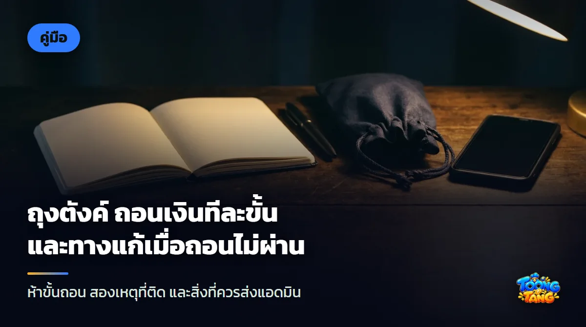 ถุงผ้าสีน้ำเงินผูกเชือกวางข้างสมาร์ตโฟนจอดับ สมุดโน้ตเปิดอยู่ และปากกา บนโต๊ะไม้สีเข้มใต้แสงไฟอุ่น